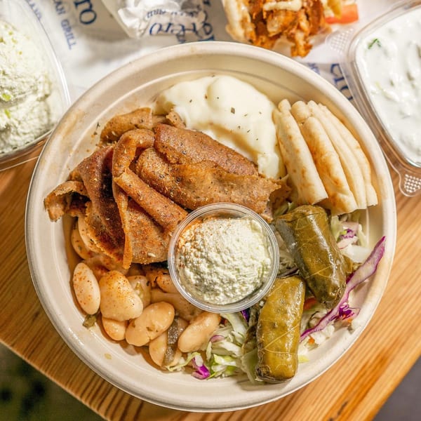 A Pita Yeero bowl with gyro meat, mashed potatoes, pita, dolmades, giant beans, and dips.