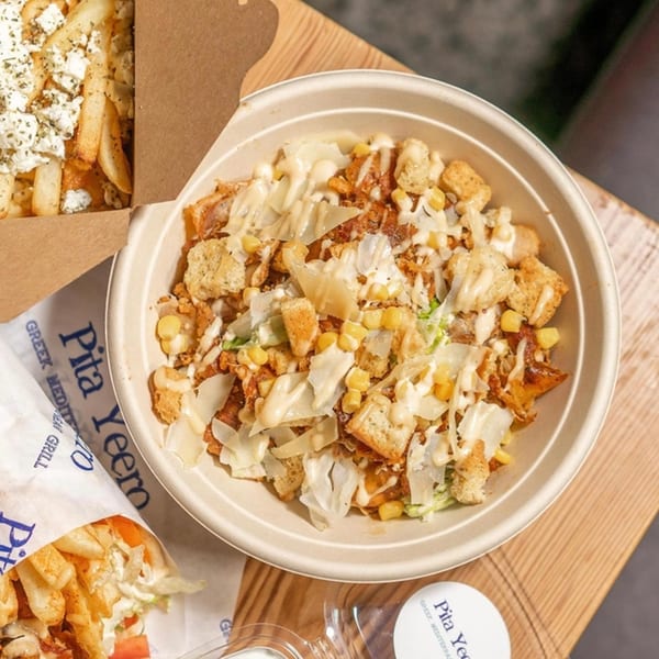 Pita Yeero chicken bowl with corn, croutons, and cheese, alongside feta fries and a gyro.